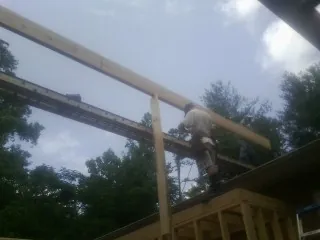 Carpenter setting a ridge beam over a new addition frame — Ice Dam Removal by Roofing Brothers in Suwanee