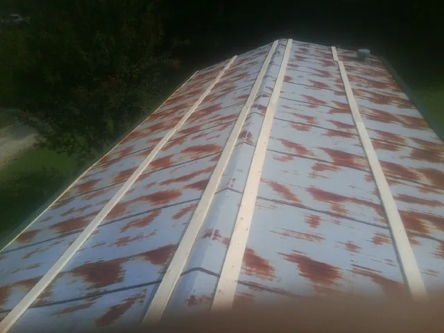 Rusted metal roof panels with new wood purlins before replacement — Storm Damage Roof Repair in Suwanee by Roofing Brothers