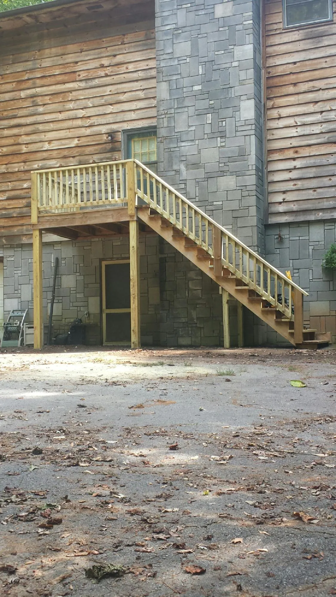 New pressure treated deck and stair landing on a log home in Suwanee