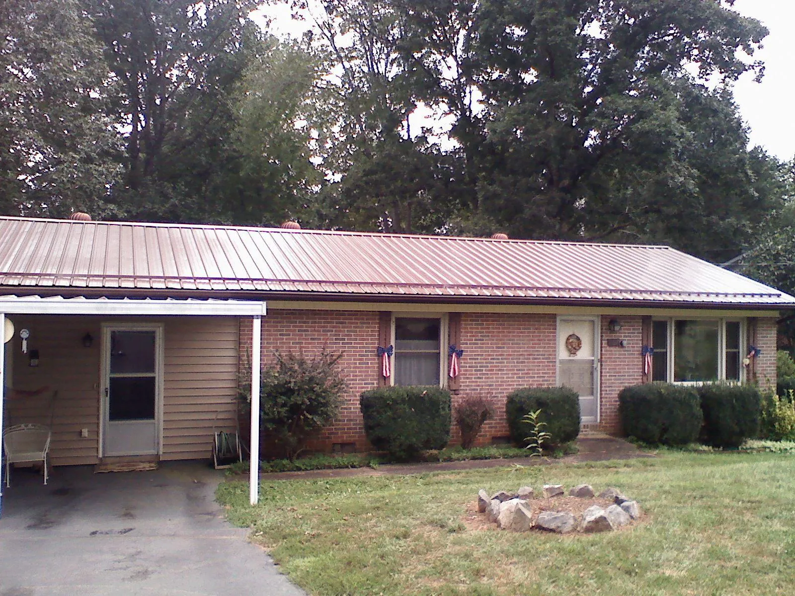 Bronze metal roof and carport on a brick ranch home — Roof Repair work by our crew in Suwanee