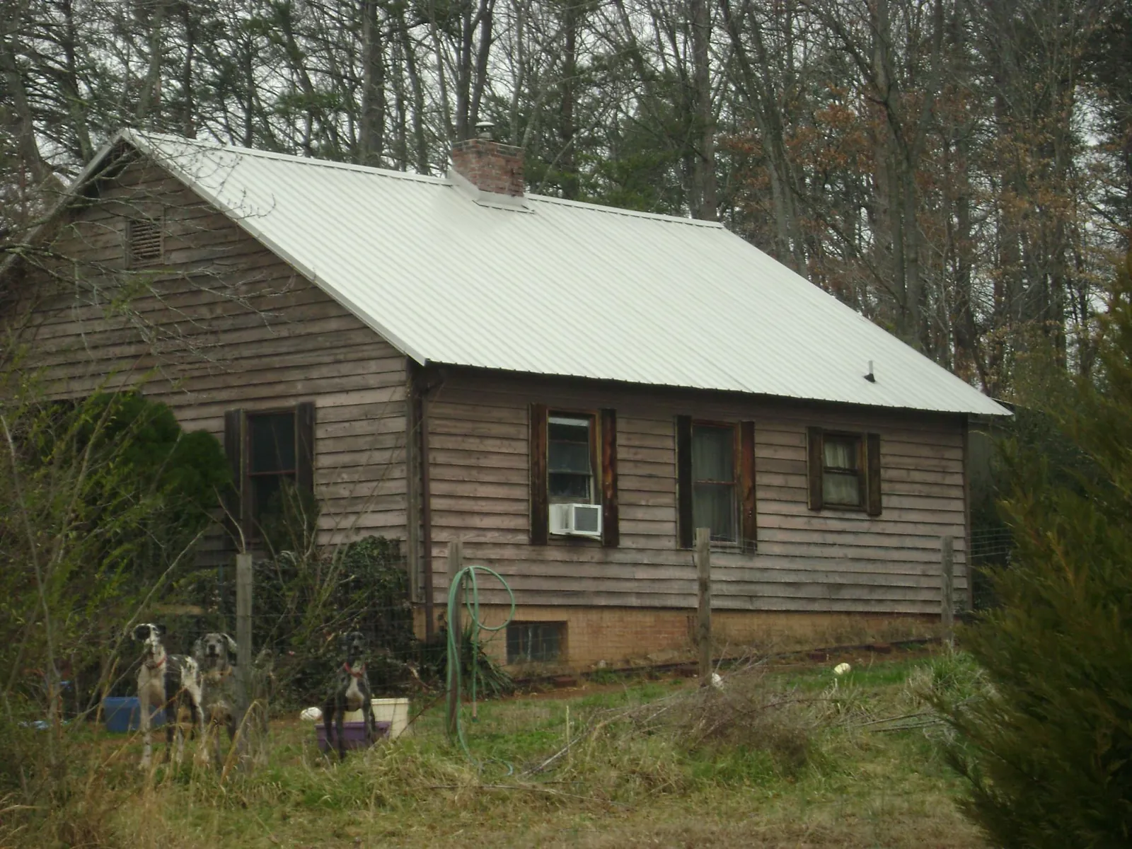 White metal roof on an old wood sided farmhouse, from a Metal Roof Installation job in Suwanee